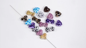 Vue détaillée des perles acryliques en forme de cœur et nœud pour bijoux DIY créatifs