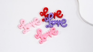 Dettaglio macro di ciondoli Love in acrilico lucido per accessori scarpe fai-da-te