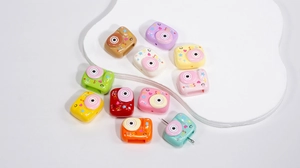 Makroaufnahme bunter Kamera-Acrylperlen mit Smile-Schriftzug für DIY-Armbänder