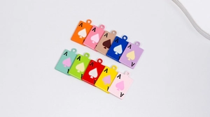 Close-up of colorful Ace of Spades charms in ten vibrant enamel colors for DIY jewelry