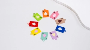 Macro view of 10 colorful enamel poker Ace charms arranged in a radial circle design