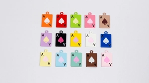 Macro detail of fifteen colorful Ace of Spades charms for DIY jewelry and keychains