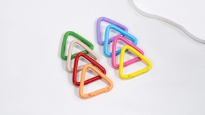 Nahaufnahme bunter Dreiecks-Karabiner aus Aluminium in acht matten Spritzlackfarben