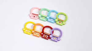 Detailed view of colorful camera-shaped alloy spring keychains in eight vibrant colors