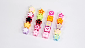 Macro shot of colorful acrylic flower star and heart beads for DIY jewelry making
