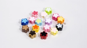 Close-up of colorful acrylic five-petal flower beads with center holes for DIY crafts