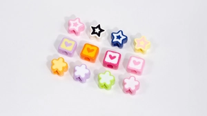 Detailed macro shot of assorted colorful acrylic DIY beads in star and flower shapes