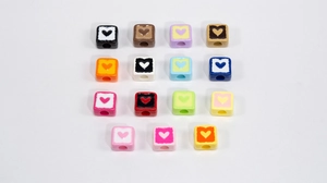 Flat lay of colorful acrylic heart cube beads for DIY jewelry making and crafts