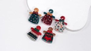 Detailed view of five Christmas themed acrylic dress charms for DIY jewelry and crafts
