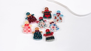 Detailed view of eight acrylic Christmas sweater charms with festive holiday patterns
