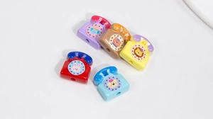 Macro shot of colorful acrylic retro phone charms with cute animal patterns and DIY holes