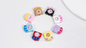 Close-up of acrylic retro telephone beads with clock dial and animal icons for DIY jewelry