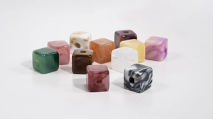 Macro detail of colorful marble texture resin cube beads with large holes for DIY crafts