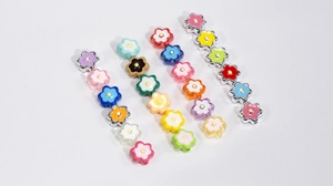 Close-up of colorful acrylic six-petal flower beads for DIY crafts and jewelry making