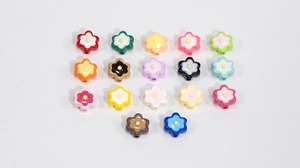 Macro detail of colorful acrylic flower beads with center yellow stamens for DIY crafts