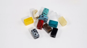 Flat lay of colorful marble textured resin square beads with holes for DIY jewelry