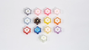 Flat lay of thirteen colorful acrylic six-petal flower beads for DIY crafts and accessories