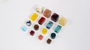 Detailed view of colorful marbled resin beads in various geometric shapes for DIY jewelry