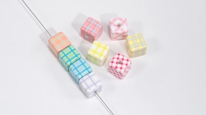 Detailed view of colorful grid pattern acrylic cube beads for DIY jewelry making