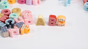 Macro shot of colorful plaid alphabet beads for DIY jewelry making and phone charms