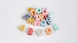 Macro detail of alphabet beads with colorful plaid texture for DIY jewelry making