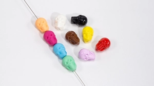 Dettaglio di perline colorate a forma di teschio in acrilico lucido e opaco per gioielli fai da te