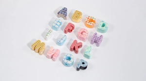 Detail view of colorful plaid alphabet beads for DIY jewelry and phone charms crafting