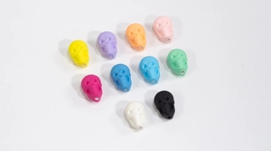 Dettaglio macro di perline a teschio 3D multicolore con fori per la creazione di gioielli