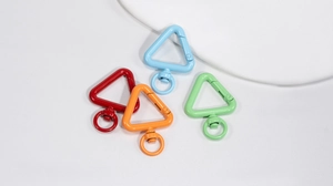 Detail of colorful triangle spring snap hooks with 360-degree swivel rings for bags