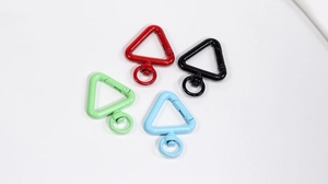 Close-up of four colorful triangular alloy carabiners with swivel rings on white background