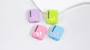 Detailed macro view of four colorful JOKER acrylic beads in purple, green, pink, and blue