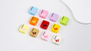 Macro shot of colorful acrylic Joker letter beads with threading holes for DIY jewelry