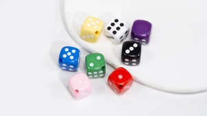 Primer plano de cuentas de dados acrílicos de 14mm en ocho colores con agujeros perforados