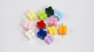 Macro detail of colorful clover acrylic beads with central hole for DIY jewelry making