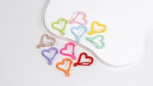 Détail macro de mousquetons en forme de cœur avec diverses finitions laquées colorées