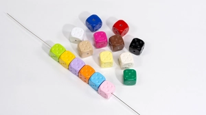 Macro shot of colorful acrylic dice beads for DIY jewelry with center threading holes