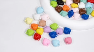 Macro detail of colorful heart-shaped acrylic pendants with radiant ribbed texture for DIY crafts