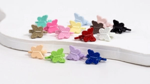 Macro-opname van kleurrijke vlinderhangers van metaal met matte afwerking voor sieraden