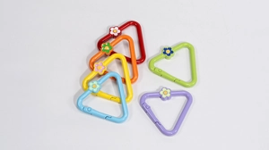 Close-up of colorful triangle spring clasps with small flower charms for DIY crafts