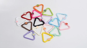 Macro detail of colorful triangle spring hooks with small flower charms for DIY crafts
