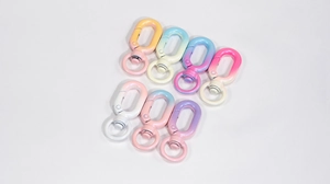 Close-up of seven macaron gradient spring rings and swivel lobster clasps for DIY keychains