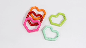 Detailansicht farbenfroher herzförmiger Karabiner in Orange, Rot, Pink und Grün