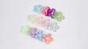 Dettaglio di perline acriliche a fiori in finiture opache, aurora e crema per gioielli DIY