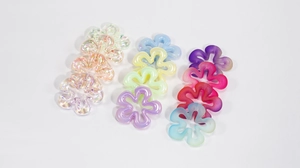 Dettaglio di perline a forma di fiore in acrilico colorato con finiture perlate e opache
