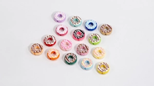 Macro shot of colorful acrylic donut beads with cream frosting and sprinkles for DIY jewelry