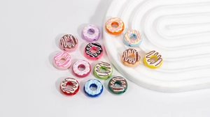 Macro shot of colorful acrylic donut beads with frosting on a white grooved tray