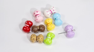 Dettaglio di perline in acrilico colorate a forma di fiocco con motivi a pois per gioielli