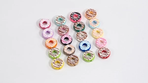 Macro shot of colorful acrylic donut beads with realistic frosting for DIY jewelry crafting