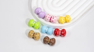 Dettaglio di perline a fiocco in acrilico colorato con pois per creazione gioielli