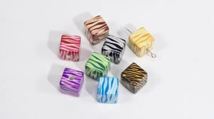 Macro shot of colorful acrylic cube beads with zebra patterns and pre-drilled holes